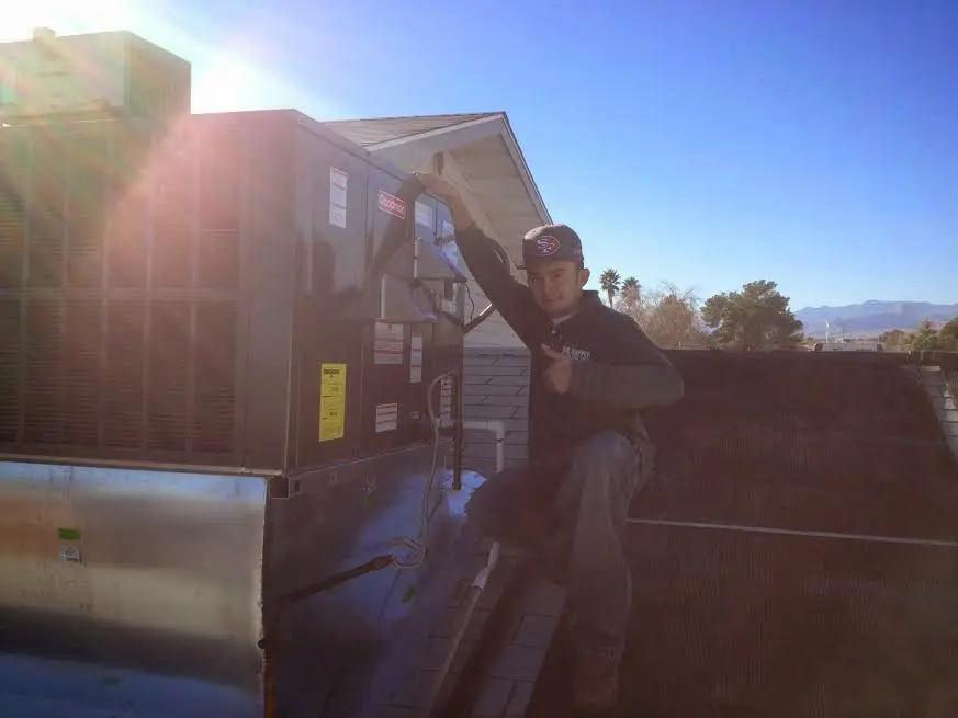 HVAC technician performing Heat Pump Repair on a rooftop unit in Sultan